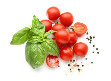 Taze fesleğen, kiraz domatesleri ve beyaz arka planda biber.