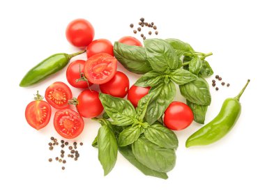 Taze fesleğen, kiraz domatesleri ve beyaz arka planda biber.