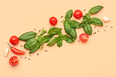 Taze fesleğen, kiraz domatesleri ve turuncu arka planda biber.