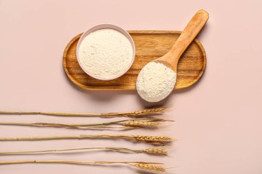 Pembe arka planda un ve buğday kulaklı kase