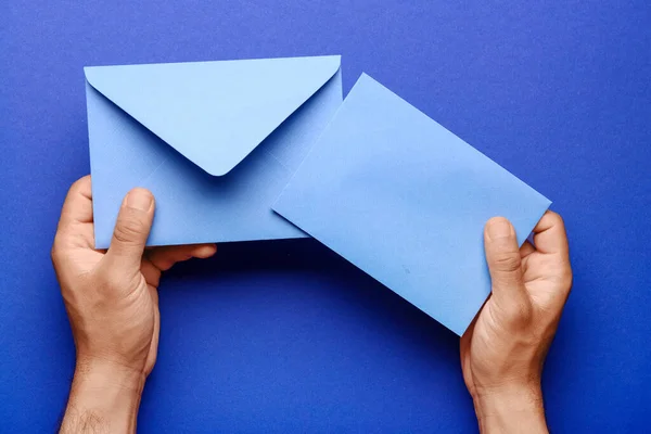 Mãos Masculinas Com Envelopes Papel Fundo Azul Close — Fotografia de Stock
