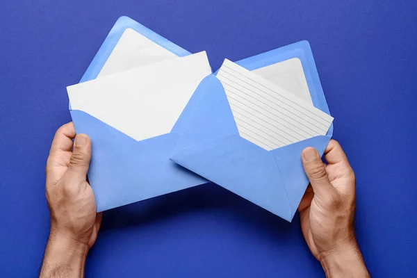 Mãos Masculinas Com Envelopes Cartões Branco Sobre Fundo Azul Close — Fotografia de Stock