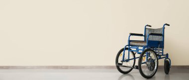 Işık duvarının yanında boş tekerlekli sandalye ve metin için boşluk