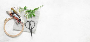 Tahta işlemeli iplikler, makas, papatya çiçekleri ve hafif arkaplan üzerinde yazı için boşluk olan tuval.