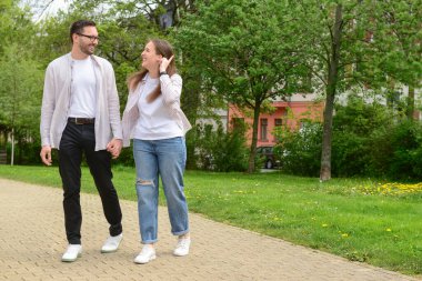 Güzel mutlu çift bahar günü parkta yürüyor.