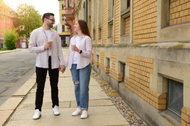 Güzel, sevgi dolu mutlu çift bahar günü kahve içip şehirde yürüyorlar.