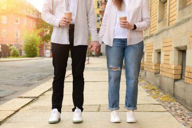 Güzel, sevgi dolu mutlu çift bahar günü kahve içip şehirde yürüyorlar.