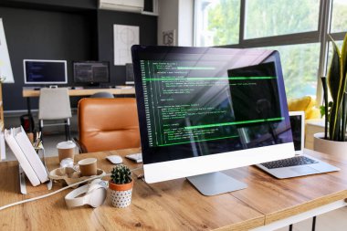Ofiste bilgisayar ve dizüstü bilgisayarı olan programcının çalışma yeri