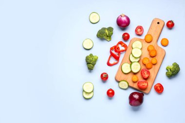 Mavi arka planda farklı taze sebzeleri olan ahşap tahta.