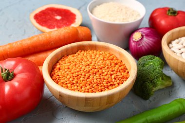 Mavi arka planda farklı taze sebzeler ve tahıllar.