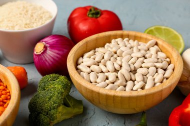 Mavi arka planda farklı taze sebzeler ve tahıllar.