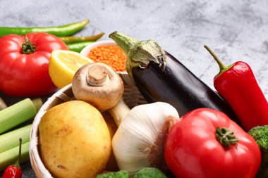 Farklı taze sebzeler ve mavi arka planda mısır gevrekleri olan hasır kase, yakın plan.