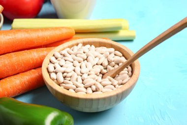 Farklı taze sebzeler ve mavi arka planda fasulye kasesi.