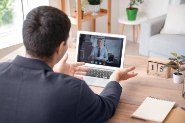 Genç bir adam internet üzerinden iş görüşmesi yapıyor, yakın plan.