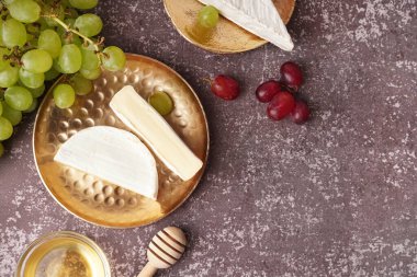 Gri arkaplanda lezzetli Camembert peyniri parçaları olan tabaklar