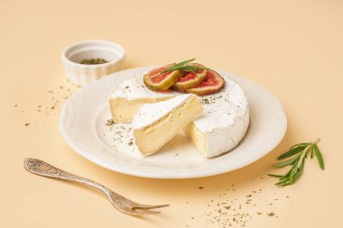 Sarı arka planda lezzetli peynirli Camembert tabağı.