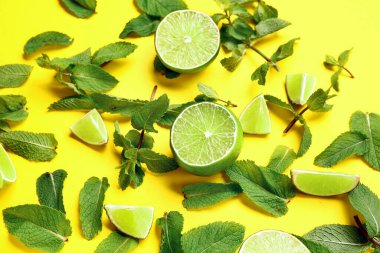 Sarı zemin üzerinde taze nane yaprakları ve limonlu kompozisyon