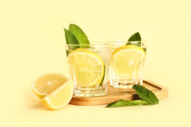Arkaplanda soğuk mojito, limon ve nane içeren ahşap bir tahta.