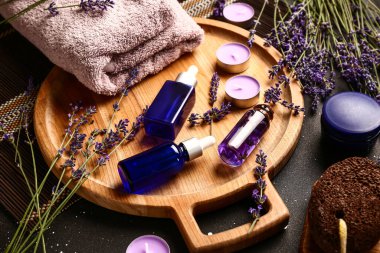 Kozmetik ürünleri, spa aksesuarları ve lavanta çiçekleri ile koyu arka planda, yakın plan