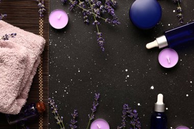 Kozmetik ürünlerden, spa aksesuarlarından ve lavanta çiçeklerinden oluşan bir çerçeve.