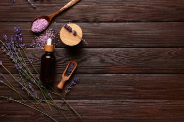 Kozmetik ürünleri ve ahşap arka planda aromatik lavanta çiçekleri olan kompozisyon