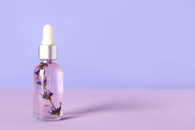 Renkli arka planda lavanta esaslı yağ şişesi
