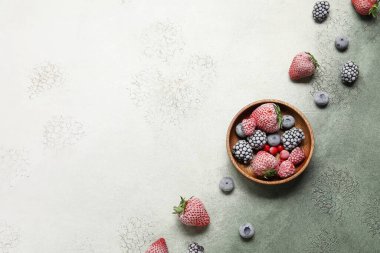 Gri arkaplanda bir kase donmuş dut.