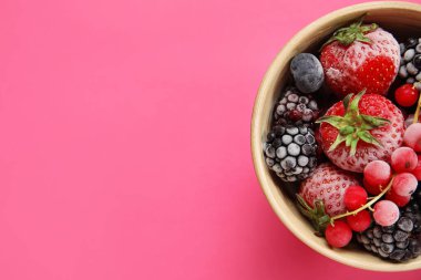 Pembe arka planda bir kase donmuş dut.