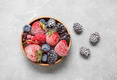 Gri arkaplanda bir kase donmuş dut.