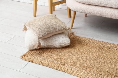 Wicker carpet with cushions in interior of living room, closeup
