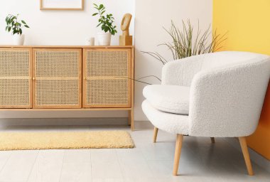 Interior of living room with white sofa, wooden cabinet and stylish rug
