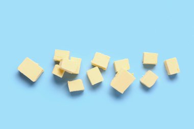 Pieces of fresh butter on blue background