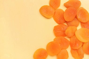 Tasty dried apricots on orange background