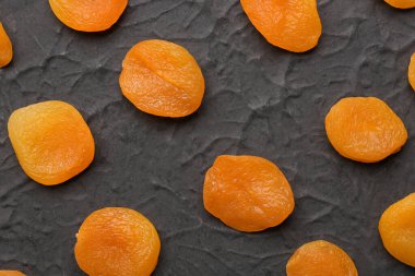 Tasty dried apricots on black background