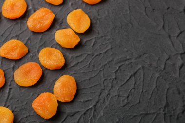 Tasty dried apricots on black background