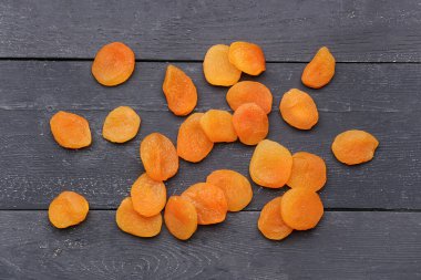 Siyah ahşap arka planda lezzetli kurutulmuş kayısılar.