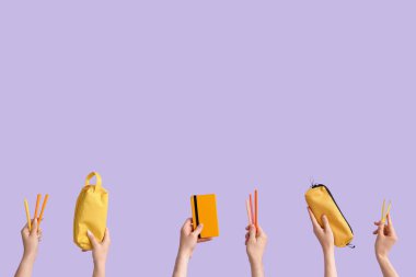 Hands with school supplies on lilac background