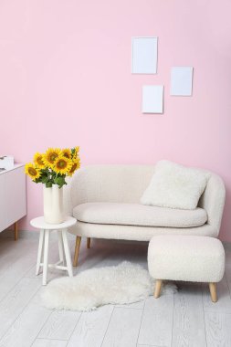 Interior of living room with sunflowers in vase on table