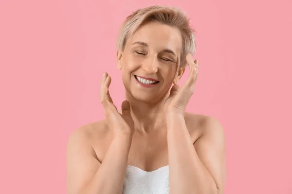Happy mature woman on pink background, closeup