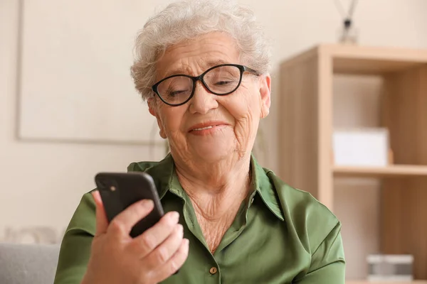 Старшая Женщина Использует Мобильный Телефон Дома Крупным Планом — стоковое фото