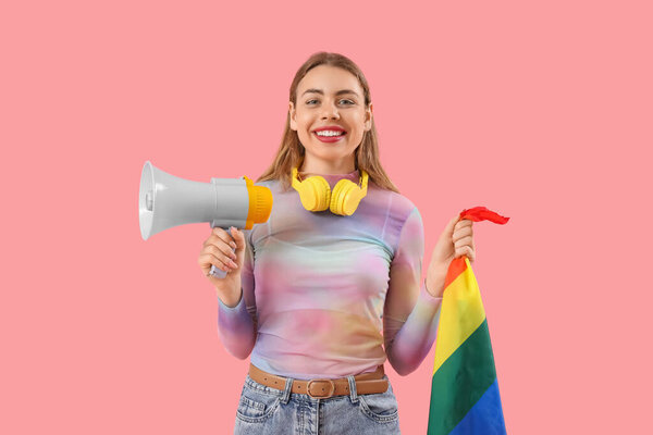 Young woman with LGBT flag and megaphone on pink background