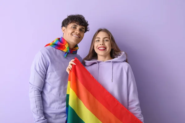 在紫丁香背景上挂Lgbt旗的年轻夫妇 — 图库照片