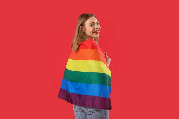 赤い背景にLgbtの旗を持つ若い女性 — ストック写真