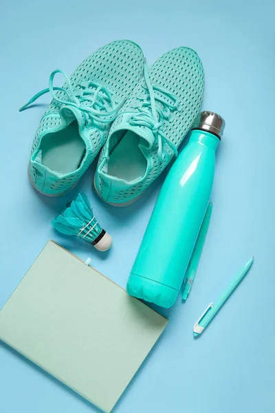 stock image Sneakers with bottle of water, badminton shuttlecock and stationery on blue background