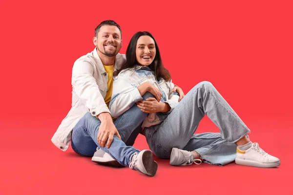 Happy Young Couple Sitting Red Background — Stock Photo, Image