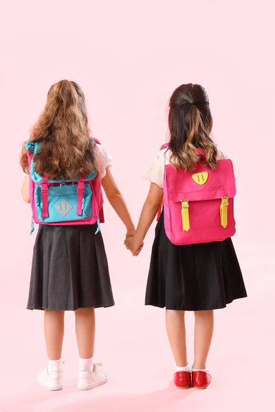 Kleine Schoolmeisjes Hand Hand Roze Achtergrond Achteraanzicht — Stockfoto