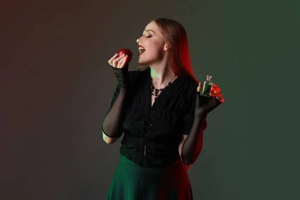 漂亮的年轻女巫 有苹果和深色背景的药水 — 图库照片