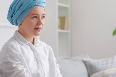 Kemoterapiden sonra genç bir kız evdeki kanepede oturuyor.