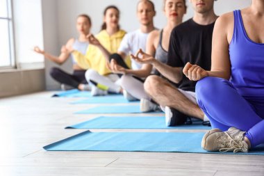Spor salonunda meditasyon yapan bir grup genç, yakın plan.