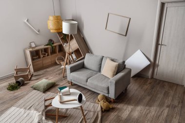 Masalı kanepe ve dağınık oturma odasında raf üniteleri.